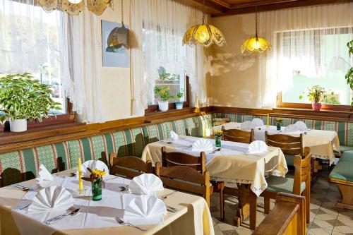 拉斯尼茨霍火车住宿加早餐旅馆的餐厅设有白色的桌椅和窗户。