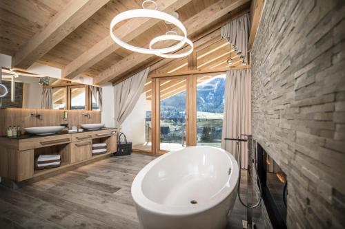 阿亨基希纳特尔-阿克提度假酒店的一间带大浴缸和大窗户的浴室