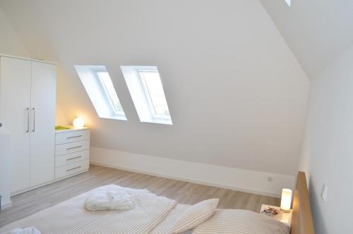 于斯德Dünenmeer的一间白色卧室,配有一张床和一个梳妆台
