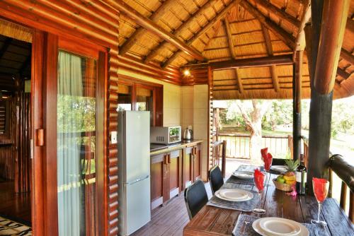 科玛蒂普特大象漫步休养度假酒店的厨房配有木桌和冰箱。