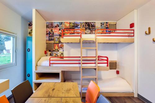 勒库德赖hotelF1 Chartres的客房设有双层床和桌椅。