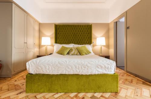 马托西纽什波尔图马尔酒店的一间卧室配有一张大床和绿色床头板