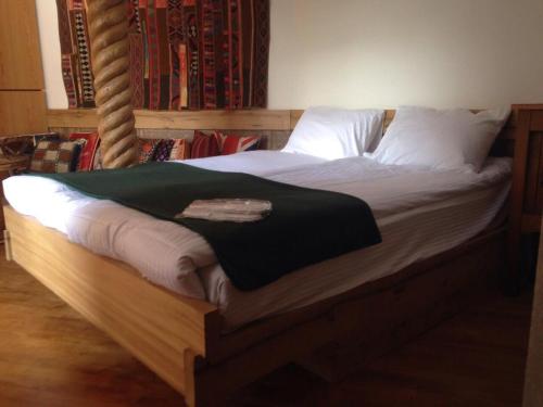 第比利斯Craftsman's Home的一张铺有白色床单的床铺和一张绿毯