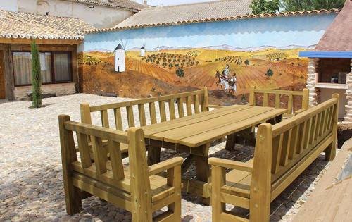 普埃尔托拉皮塞Casa Rural La Tia Lola的壁画前的木桌和长椅