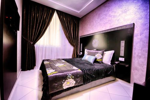 索维拉Hotel Vents Des Iles的紫色客房内的一间卧室,配有一张床