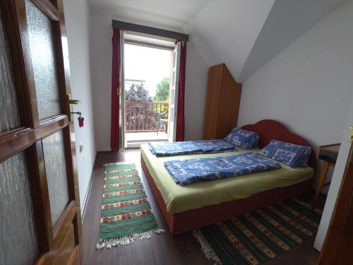 下厄尔什Barátság Ház的一间小卧室,配有床和窗户