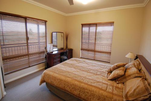 珀斯Mountain Park Retreat的一间卧室设有一张床和两个大窗户