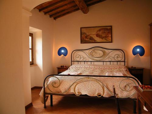 瓦尔的圣卡西亚诺马基雅维利泉水住宿加早餐酒店的一间卧室配有一张带蓝色灯具的床。