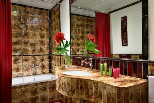 佛罗伦萨贝尔基耶利酒店的一间带水槽和红色窗帘的浴室