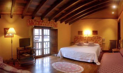 QuijasPosada Andariveles的卧室配有白色的床和电视。