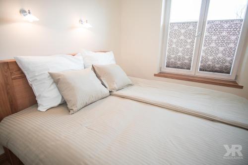 塔尔图Maria 4 Apartment的卧室内的一张带白色床单和枕头的床