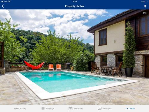 大特尔诺沃Veliko Tarnovo Villa Lora的一个带椅子的游泳池以及一座房子