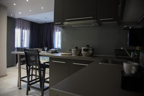 艾斯普罗瓦塔B. U. Luxury Apartments的厨房配有黑色橱柜和台面