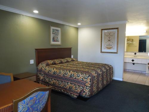 奥兰治卡斯塔维汽车旅馆的酒店客房配有一张床铺和一张桌子。