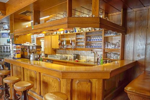 巴德艾森卡珀尔Gasthof Podobnik的餐厅内的酒吧,设有木墙和凳子