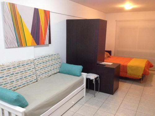 布兰卡港Las Marinas Rent的一间卧室配有床、长凳和绘画