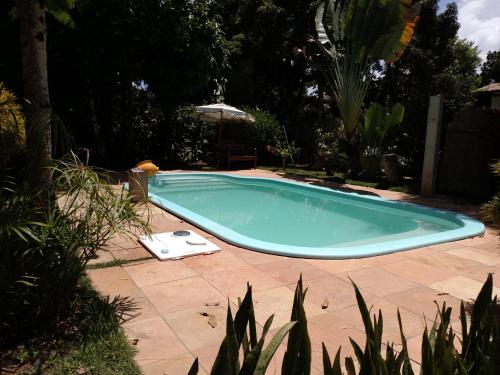 巴拉格兰德Suíte Bella Vista的一个带遮阳伞的庭院内的游泳池