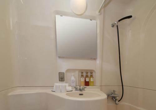 足利新宫古酒店足利别馆的浴室设有水槽、镜子和淋浴