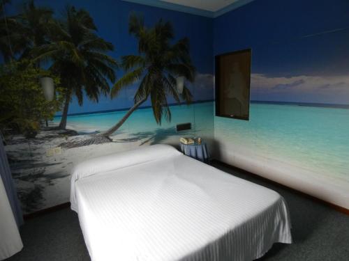 卡尔达斯·德·雷斯Motel Caldas的卧室配有白色的床和海滩画