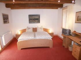 克劳斯塔尔采勒费尔德俊峰旅馆的一间卧室配有一张大床和电视