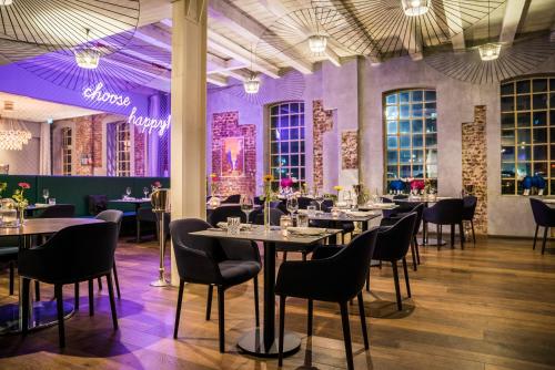 吉森荷利根斯塔特酒店的一间配备有桌椅和紫色照明的用餐室