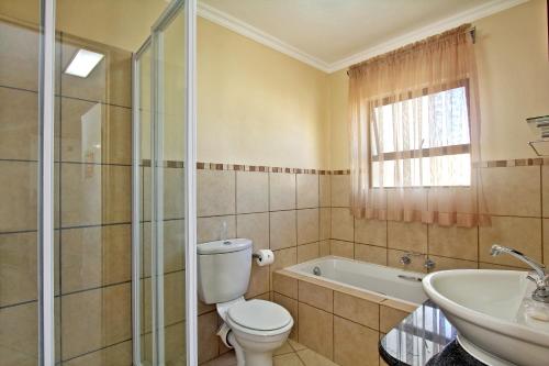 马盖特Uvongo River Resort的浴室配有卫生间、浴缸和水槽。
