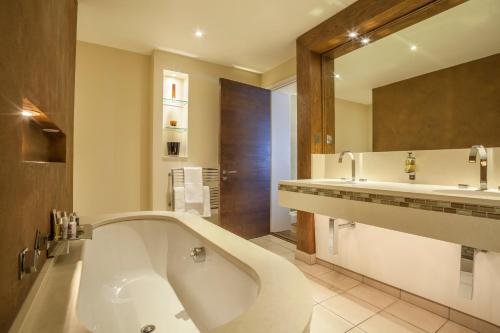 雷丁罗斯特里盯酒店的一间带浴缸和大镜子的浴室