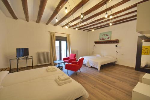 CascantePension Casa Pinilla的一间卧室配有两张床和红色椅子