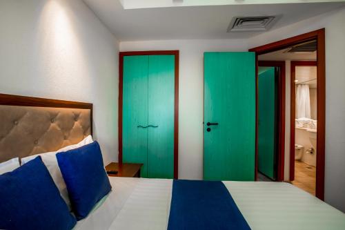 埃拉特Club In Eilat - Coral Beach Villa Resort的卧室设有绿色和蓝色的门和一张床