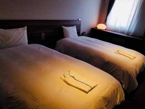 神户布伦扎酒店 的两张睡床彼此相邻,位于一个房间里