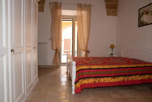 GiulianoCasa Jacqueline al borgo的一间卧室设有一张床,一扇门通往窗户