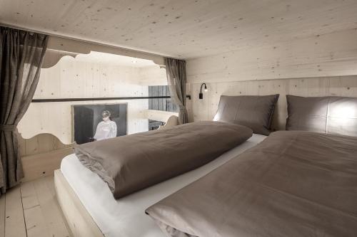 塞尔瓦迪加尔代纳山谷Artefugium Atelier - Apartments的一间卧室设有一张大床,窗户上设有一名女士