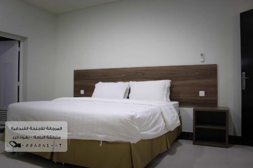 巴哈المرجانة للشقق المفروشه للعائلات Al Murjana Furnished Apartments for Families的一间卧室配有一张大床和木制床头板