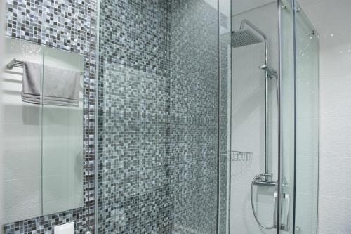 塞辛布拉Tropical house的带淋浴的浴室和玻璃门