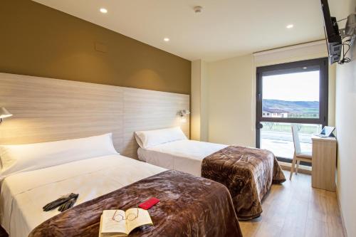 HormillaHotel Hormilla的酒店客房设有两张床和窗户。
