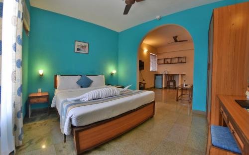 巴加普莱德桑村温泉度假酒店的一间卧室设有一张蓝色墙壁的大床