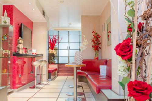 米兰苏萨酒店的一间客厅,配有红色家具和红色玫瑰