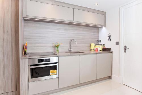 约克58 Cocoa Suites PARKING INCLUDED的厨房配有白色橱柜和水槽
