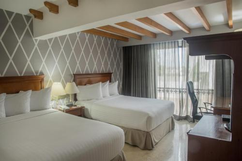 切图马尔Continental Caribe Bay的酒店客房设有两张床和窗户。