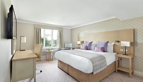 萨顿科尔菲尔德贝尔弗里度假酒店的酒店客房设有一张大床和一张书桌。