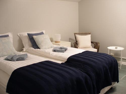 ÁrnesÁsaskóli的一间卧室配有两张带蓝白色床单的床
