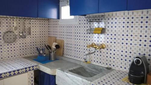 东塞斯特里nel cuore di sestri的厨房配有水槽以及蓝色和白色的瓷砖