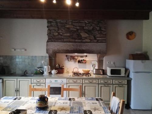 普勒默尔博杜Côte de granit rose的厨房配有桌子和白色冰箱。
