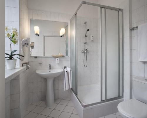 华沙MDM市中心酒店的带淋浴和盥洗盆的白色浴室