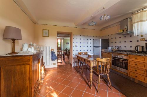 卢卡Casa Orsolini的厨房配有桌子和一些椅子
