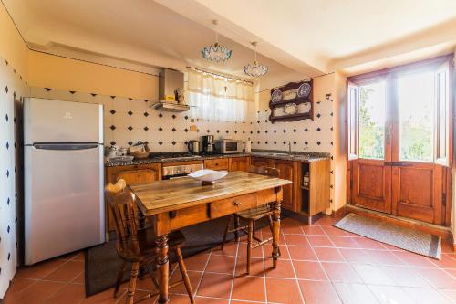 卢卡Casa Orsolini的厨房配有木桌和冰箱。