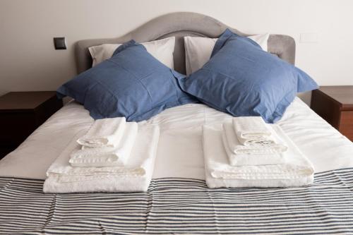 里斯本Apartamento Arrabida的一张带蓝色枕头的床和毛巾