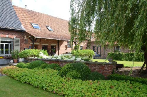 WervikHotel het Elsland的前面有花园的砖房