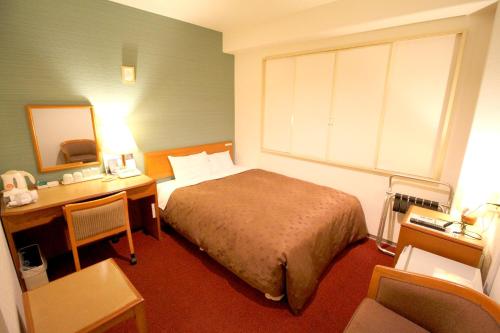东京Smile Hotel Tokyo Shinkoiwa的一间卧室配有一张床和一张带镜子的书桌