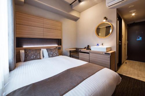 福冈博多海斯派瑞拉酒店的一间卧室设有一张大床和一个水槽
